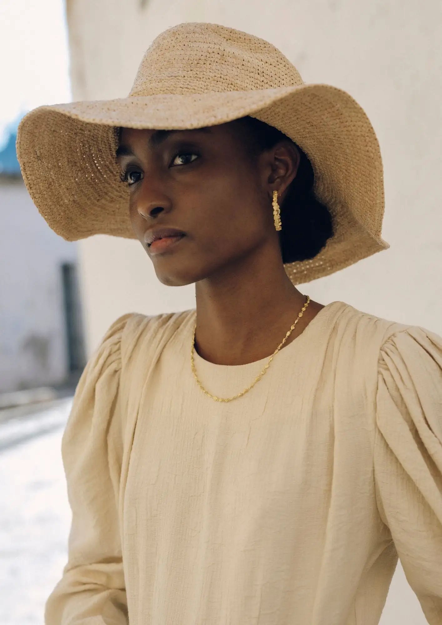 Beige straw sun hat with a wide brim and woven texture.